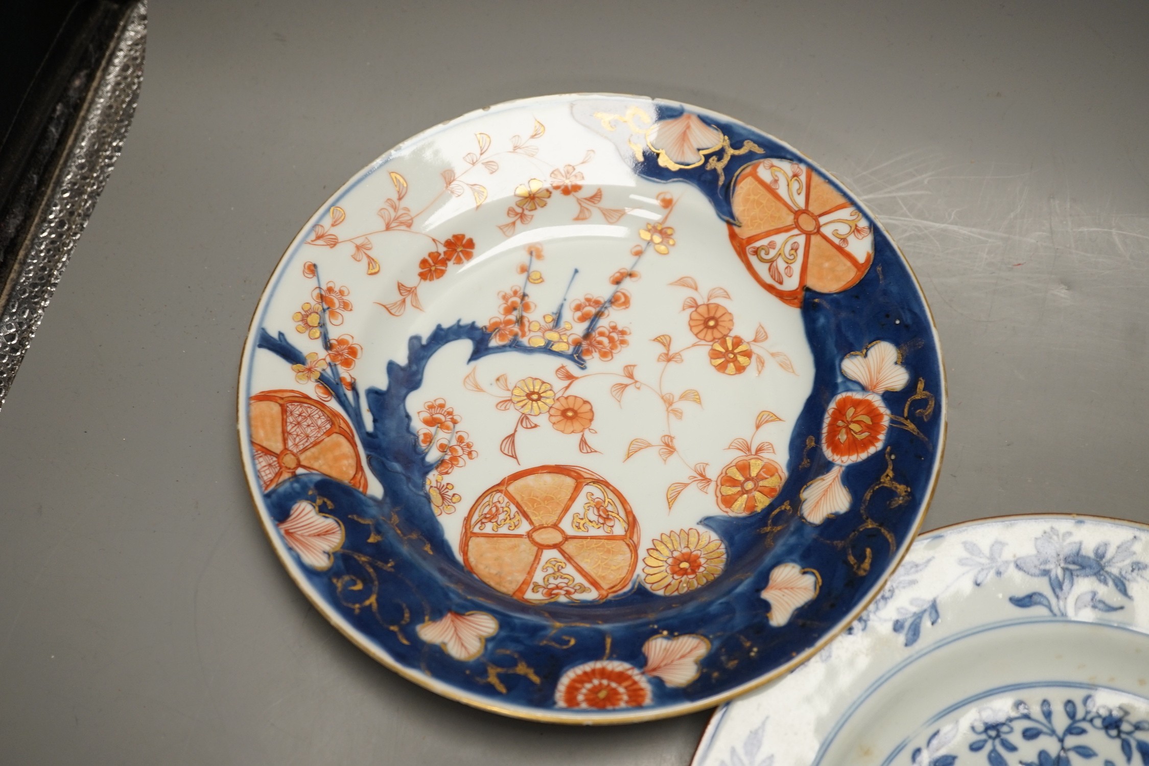 Four Chinese 18th century plates and a late 19th century blue and white dragon plate, largest 24cm diameter